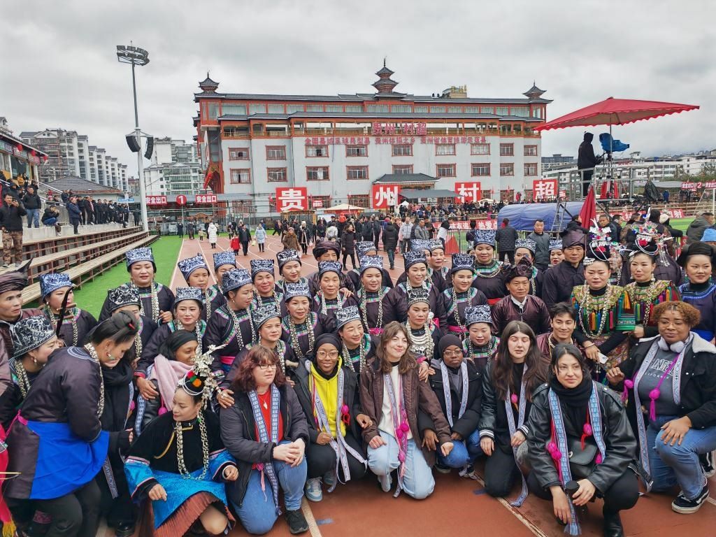 法國青年在“村超”賽場邊與參加表演的村民合影。新華社記者 羅羽 攝