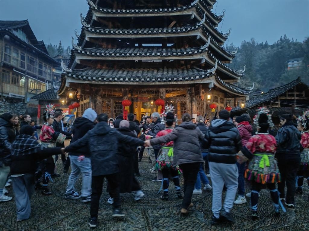 法國青年與當(dāng)?shù)卮迕駹渴痔?。新華社記者 羅羽 攝