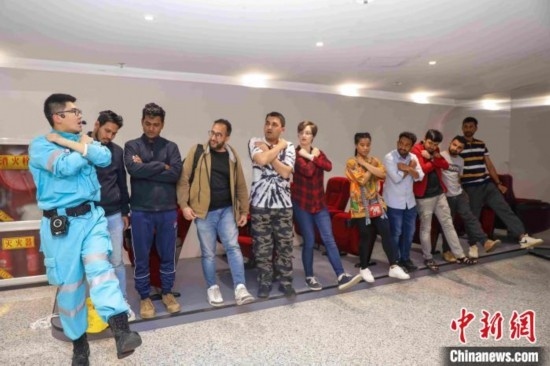 5月9日，工作人員指導留學生練習逃生技巧。張鷹 攝