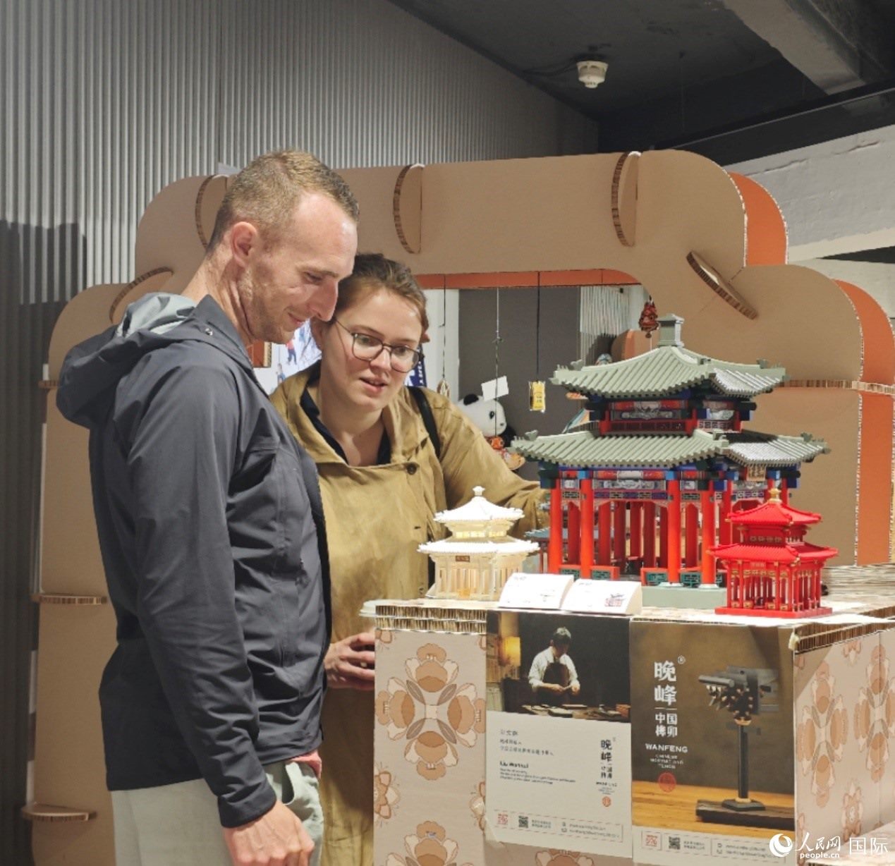 英國觀眾在欣賞中國傳統(tǒng)榫卯結構建筑模型。邢雪攝