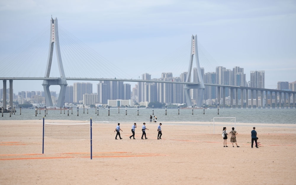 2023年7月17日，廣東湛江五環(huán)廣場(chǎng)的沙灘上，公安民警在執(zhí)勤巡邏。新華社記者 鄧華 攝