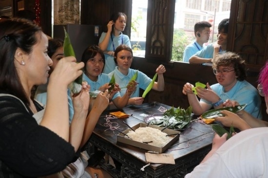 6月9日，美國青年代表在重慶永川松溉古鎮(zhèn)體驗包粽子。新華社記者 周思宇 攝