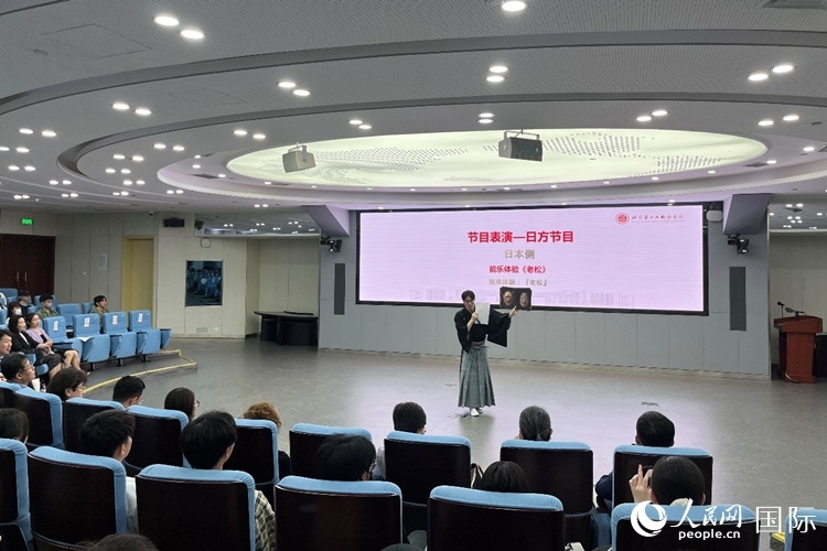 日本大學(xué)生介紹能樂知識(shí)。人民網(wǎng)記者 陳思攝