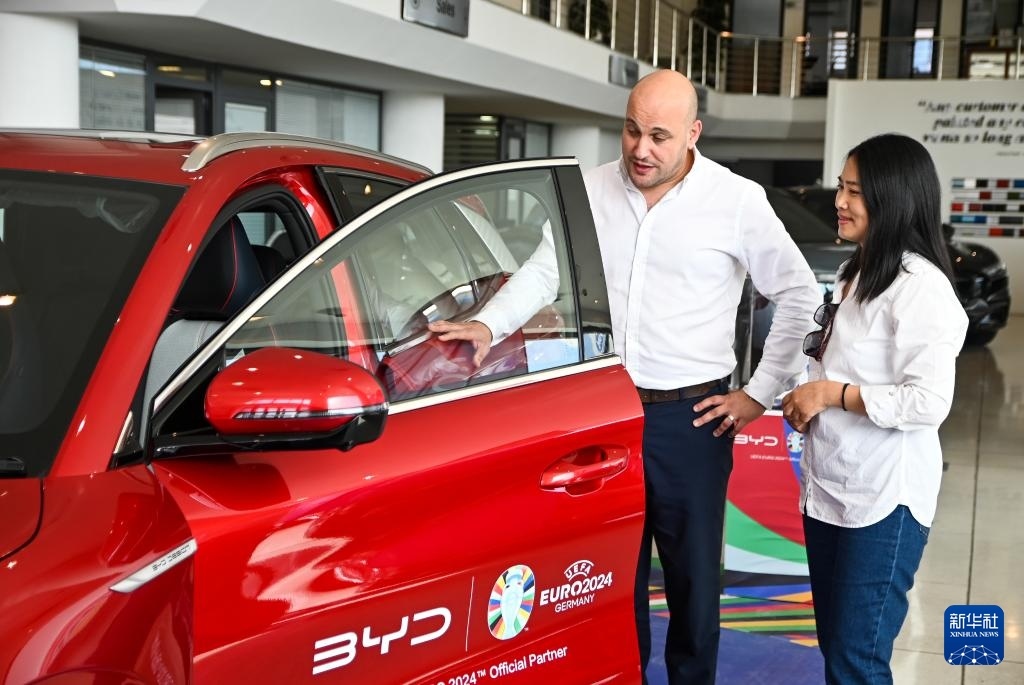 2024年5月29日，在馬耳他比爾基卡拉，馬耳他哈桑-扎米特汽車(chē)公司首席執(zhí)行官德古阿拉（左）介紹一輛比亞迪純電動(dòng)汽車(chē)。新華社發(fā)（喬納森·博格 攝）