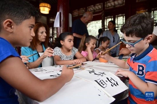 7月4日，在馬耳他桑塔露琪亞市的中國古典園林“靜園”，人們體驗中國書法。新華社發(fā)（喬納森·博格 攝）