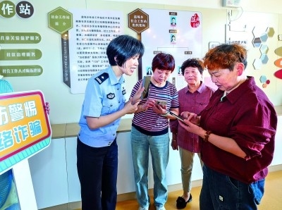 浙江湖州民警指導居民加入湖州“e企安”微信群，實時接收反詐信息。新華社發(fā)