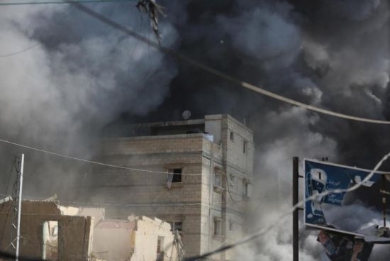 7月21日，在加沙地帶中部的努賽賴特難民營(yíng)，遭以軍空襲的建筑冒出滾滾濃煙。新華社發(fā)（馬爾萬(wàn)·達(dá)烏德攝）