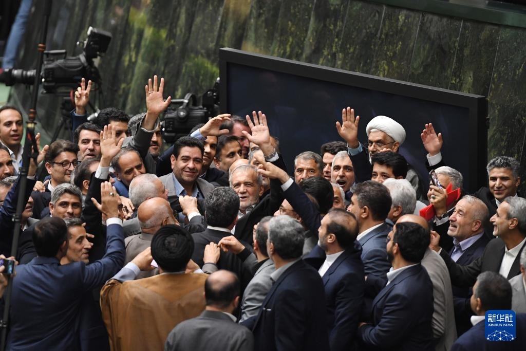 7月30日，在伊朗德黑蘭的伊朗議會(huì)，佩澤希齊揚(yáng)（中）離開(kāi)總統(tǒng)就職典禮現(xiàn)場(chǎng)時(shí)揮手致意。新華社記者 沙達(dá)提 攝