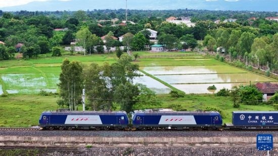 8月5日，由老撾籍火車司機(jī)獨(dú)立駕駛的滿載貨物的列車駛出萬象站，向中國(guó)昆明進(jìn)發(fā)（無人機(jī)照片）。新華社發(fā)（楊永全 攝）