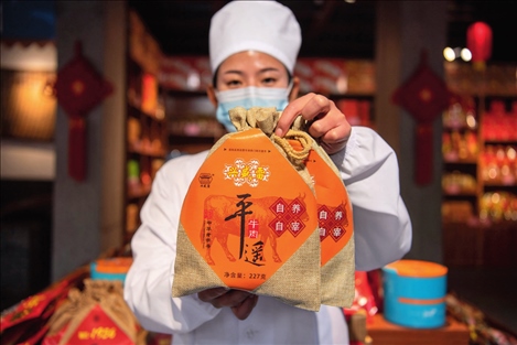 在位于山西省晉中市平遙縣的平遙古城南大街的一家平遙牛肉店內(nèi)，工作人員展示一款牛肉產(chǎn)品（資料照片）楊晨光攝 / 本刊