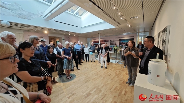 參展人、景德鎮(zhèn)陶瓷大學(xué)美術(shù)學(xué)院副院長(zhǎng)邵長(zhǎng)宗（右一）向來(lái)賓介紹參展作品。人民網(wǎng)記者 殷淼攝