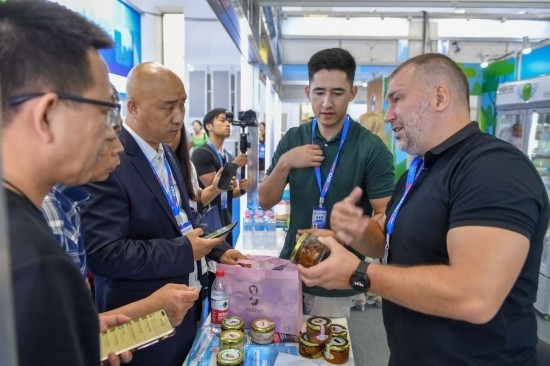 2023年8月23日，在第十四屆中國(guó)—東北亞博覽會(huì)東北亞商品館，俄羅斯參展商向參觀者介紹商品。
