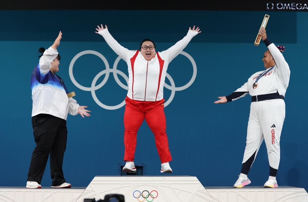 中國(guó)選手李雯雯（中）在巴黎奧運(yùn)會(huì)舉重女子81公斤以上級(jí)頒獎(jiǎng)儀式中登上領(lǐng)獎(jiǎng)臺(tái)（2024年8月11日攝）。新華社記者 楊磊 攝