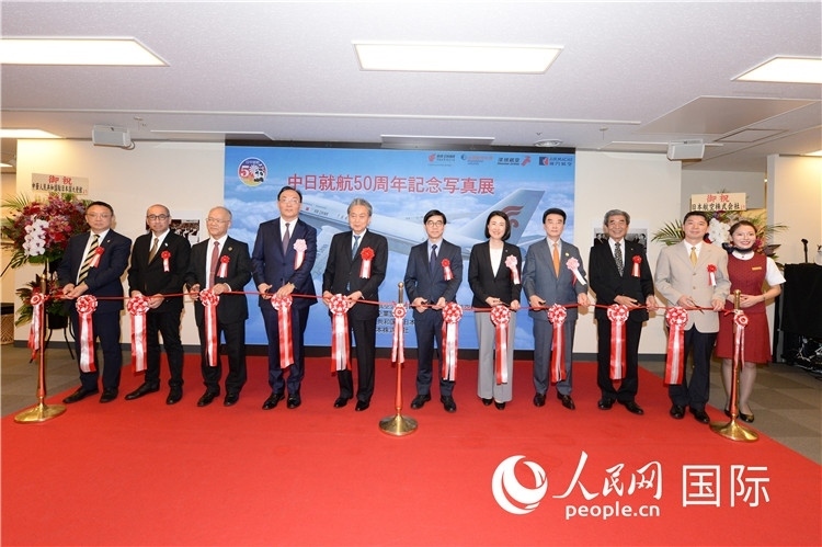 與會嘉賓共同為中日通航50周年紀(jì)念圖片展開幕剪彩。馮學(xué)敏攝