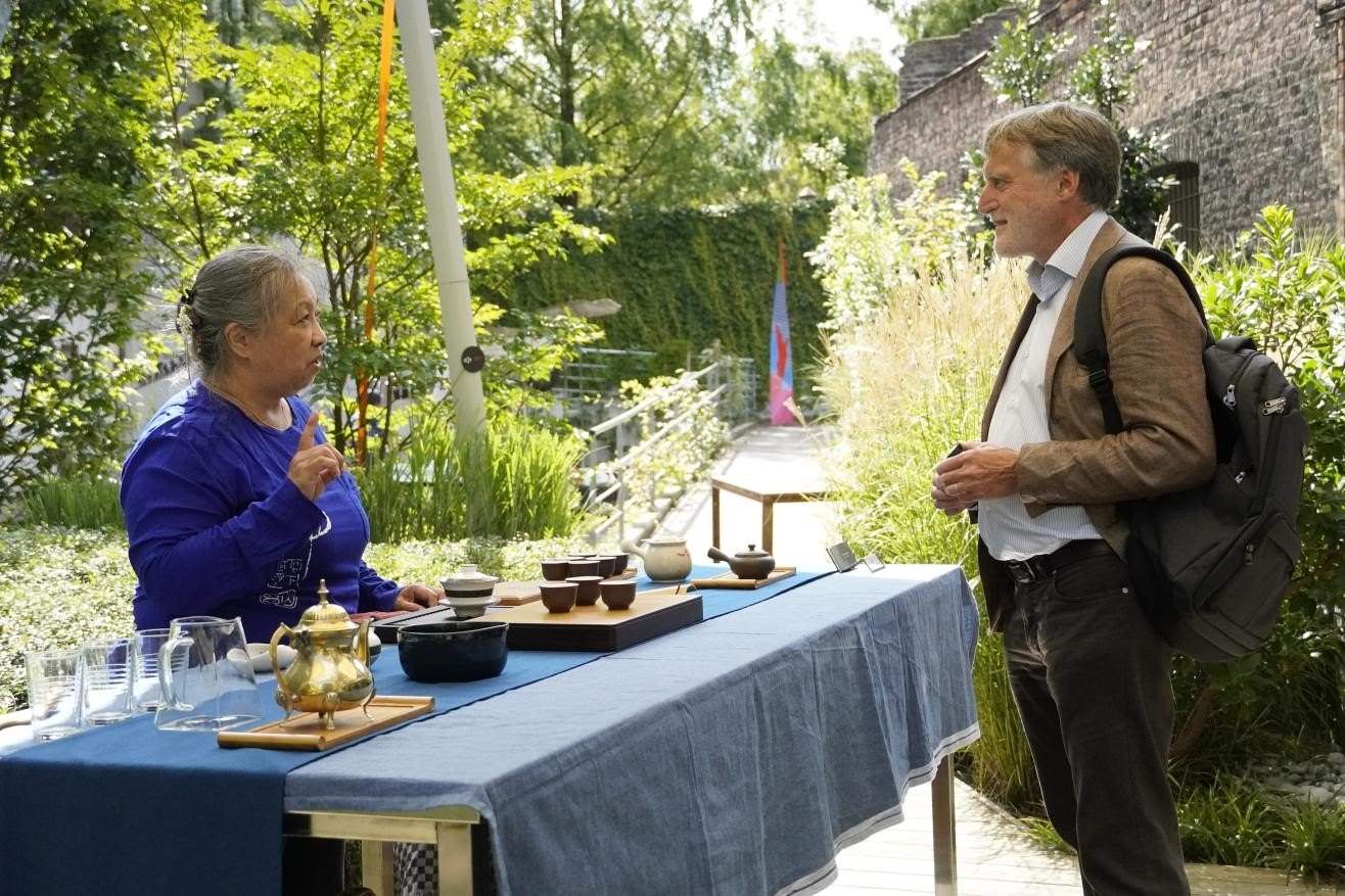 在博物館的戶外花園來賓品味中國茶藝。比利時(shí)維他命文化傳媒供圖