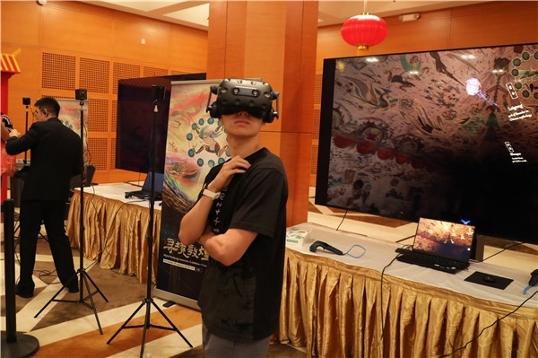1、在本次活動的展覽現(xiàn)場，敦煌研究院與騰訊展示了“數(shù)字藏經(jīng)洞”和“尋境敦煌”等創(chuàng)新互動產(chǎn)品。圖為當(dāng)?shù)孛癖娡ㄟ^VR虛擬游覽洞窟。 人民網(wǎng)記者 李志偉攝