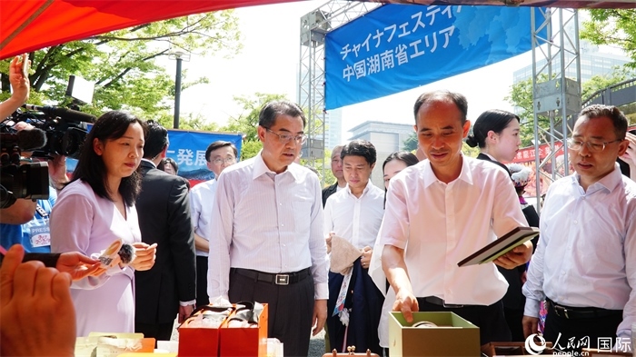 湖南展位工作人員向中國駐日本大使吳江浩介紹特色文創(chuàng)產(chǎn)品。人民網(wǎng) 蔣曉辰攝