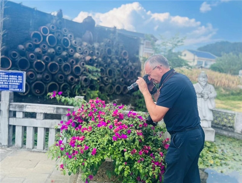 遠(yuǎn)處黔北民居錯(cuò)落有致，近處一只黑色的蝴蝶穿梭于粉紫色三角梅花叢間隙，與俄羅斯“大歐亞”總編輯弗拉基米爾·別列日內(nèi)赫的鏡頭玩起了捉迷藏，“你追我逃，不亦樂(lè)乎”。（張亞欣攝）