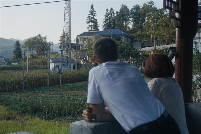 望得見(jiàn)山，看得見(jiàn)水，記得住鄉(xiāng)愁。每個(gè)人心中都有一個(gè)屬于自己的“花茂村”，在這方心田，走遍千山萬(wàn)水，鄉(xiāng)音未改鬢毛衰。吉爾吉斯斯坦《比什凱克晚報(bào)》第一副總編輯妮娜·尼奇博洛娃與《中國(guó)與俄羅斯》雜志社社長(zhǎng)奧列格·別列日內(nèi)赫攝在花茂村民居屋檐下并肩佇立，眺望山水，尋覓鄉(xiāng)愁。（李光裕攝）