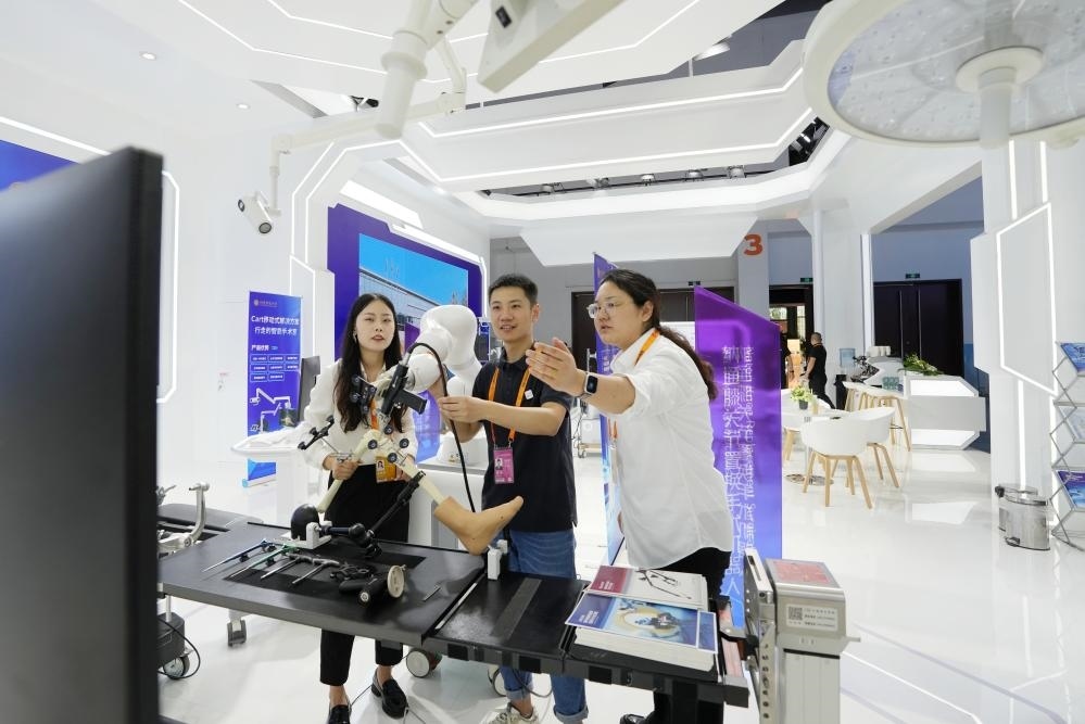 9月11日，一位媒體記者（中）在2024年服貿(mào)會(huì)國(guó)家會(huì)議中心會(huì)場(chǎng)體驗(yàn)北京納通科技集團(tuán)有限公司的膝關(guān)節(jié)置換手術(shù)機(jī)器人。新華社記者鞠煥宗 攝