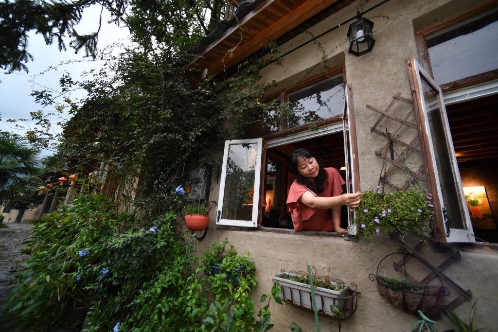 8月29日，在福建省屏南縣熙嶺鄉(xiāng)，龍?zhí)洞濉靶麓迕瘛泵泛暝诖蚶碜约航?jīng)營的民宿外墻裝飾花盆。新華社記者姜克紅 攝