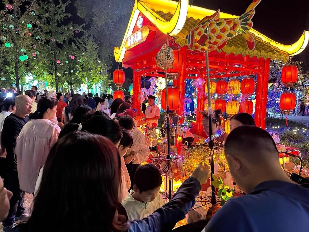 市民游客在2024年北京中秋國慶彩燈游園會上選購特色文創(chuàng)商品。新華社記者楊淑君 攝