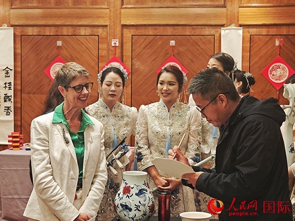 現(xiàn)場的非遺傳承人為英國觀眾展示畫技。人民網(wǎng)記者 邢雪攝