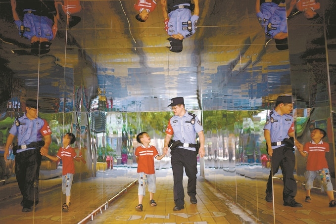 ?7月16日，重慶市公安局江北區(qū)分局一名民警在巡邏途中遇到一個獨自玩耍的小男孩，民警將其送回家。王洪平攝