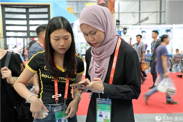 東博會(huì)現(xiàn)場，馬來西亞展商在同中方工作人員交談。人民網(wǎng)記者 趙益普攝