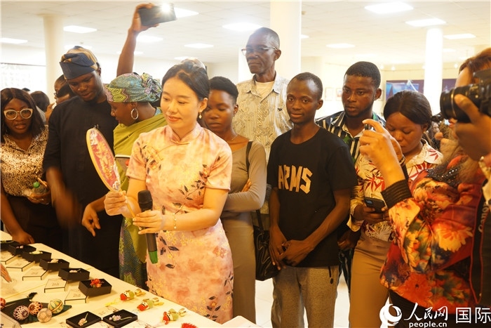 向尼日利亞觀眾介紹中國(guó)刺繡。人民網(wǎng)記者 姜宣攝