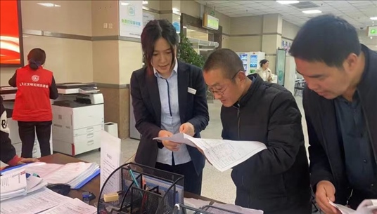 四川省成都市溫江區(qū)市場(chǎng)監(jiān)管局工作人員為群眾提供幫辦服務(wù)。圖片來(lái)源：人民網(wǎng)四川頻道