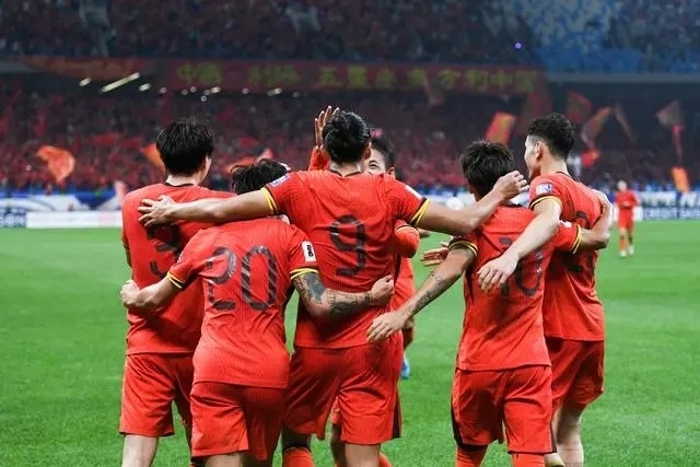 10月15日晚，張玉寧（9號(hào)）進(jìn)球后與隊(duì)友擁抱慶祝。新華社記者 李紫恒攝