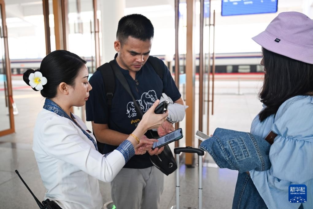 10月12日，在老撾萬象中老鐵路萬象站，工作人員檢驗乘客車票。新華社記者 程一恒 攝