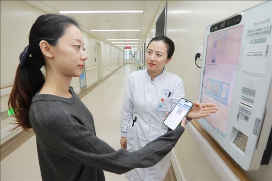 醫(yī)護(hù)人員引導(dǎo)患者在自助機(jī)前辦理自助入院手續(xù)。圖片來源：山東第一醫(yī)科大學(xué)第二附屬醫(yī)院