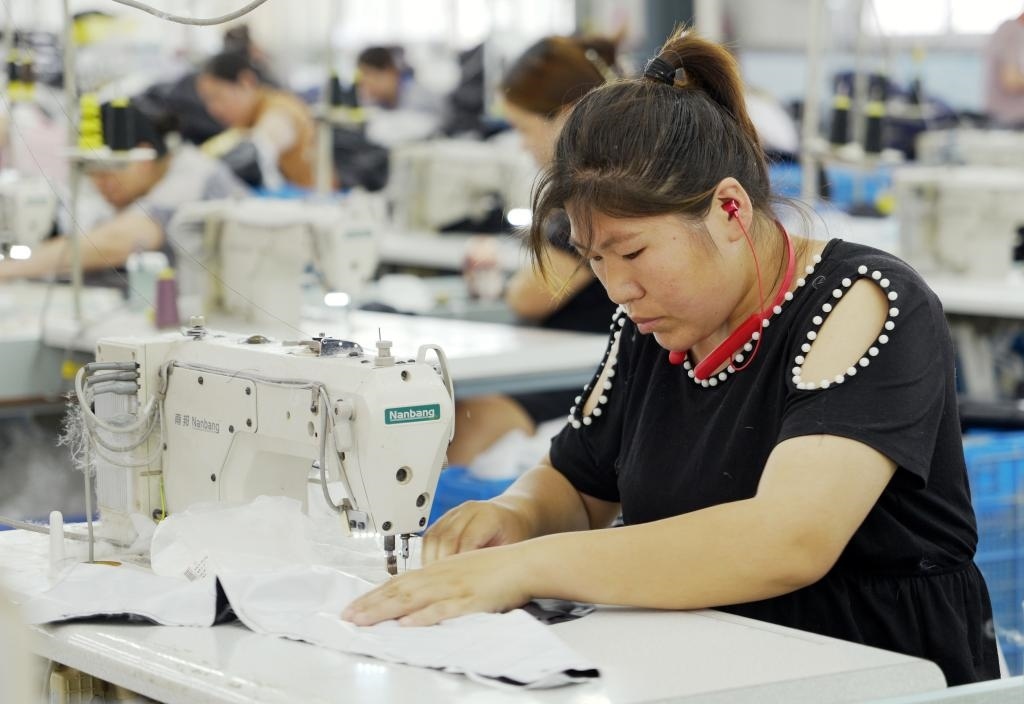 5月20日，村民在李寨村服裝加工廠內忙碌。河南省周口市沈丘縣馮營鎮(zhèn)李寨村地處豫東平原。近年來，乘著脫貧攻堅與鄉(xiāng)村振興政策的東風，李寨村積極探索產業(yè)發(fā)展模式，通過“龍頭企業(yè)+村集體經濟+農戶”的方式，逐漸發(fā)展形成肉牛養(yǎng)殖、設施農業(yè)、服裝加工、康養(yǎng)民宿等產業(yè)，以產業(yè)振興助力鄉(xiāng)村振興。新華社記者 李嘉南 攝