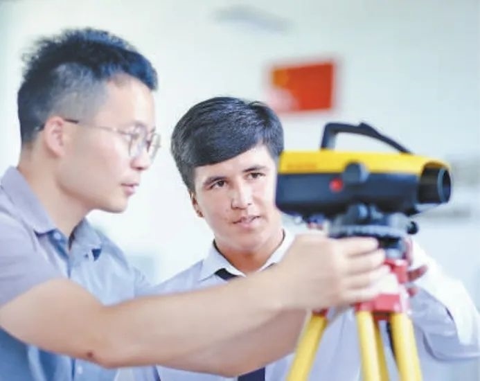 在塔吉克斯坦首都杜尚別的魯班工坊，來自天津城市建設(shè)管理職業(yè)技術(shù)學(xué)院的老師（左）為當(dāng)?shù)貙W(xué)生提供指導(dǎo)。新華社記者 鄭開君 攝