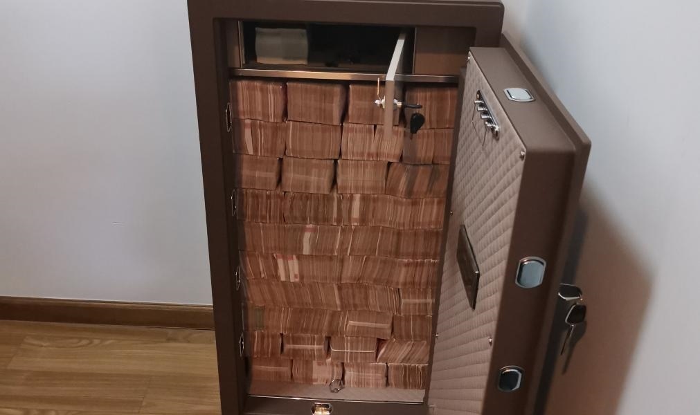 圖為警方查獲藏匿于保險柜中的現(xiàn)金。（警方供圖）