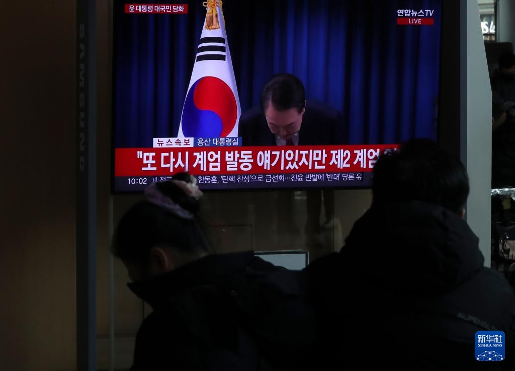 12月7日，在韓國(guó)首爾火車站，民眾觀看總統(tǒng)尹錫悅發(fā)表講話的電視畫面。新華社記者 姚琪琳 攝