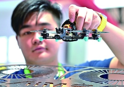 在首屆晉江科技成果轉(zhuǎn)化對接洽談會智能裝備展位，工作人員在展示無人機研究成果。新華社發(fā)