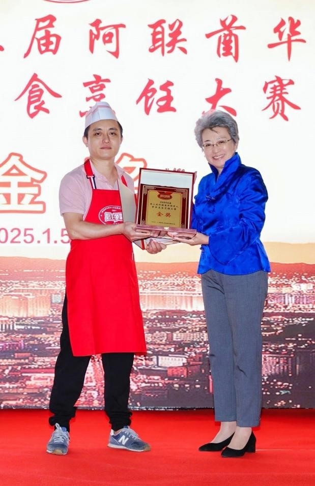 中國駐迪拜總領(lǐng)事歐渤芊（右）為金獎獲得者頒獎。主辦方供圖