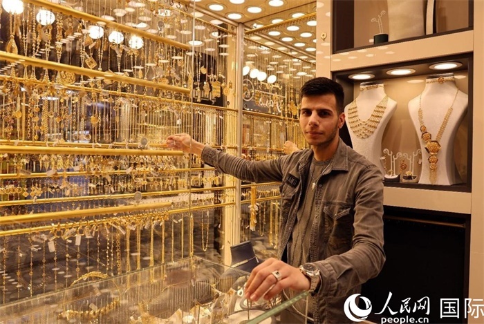 一名銷售員展示黃金飾品。人民網(wǎng) 伊納斯·易卜拉欣攝