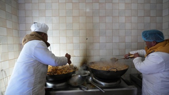 1月14日，服務(wù)隊(duì)的兩名廚師正在為村民們做午飯。新華社記者 邱星翔 攝