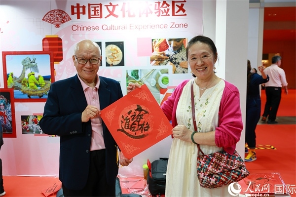 本地觀眾在中國文化體驗區(qū)展示書法作品。人民網(wǎng)記者 白元琪攝