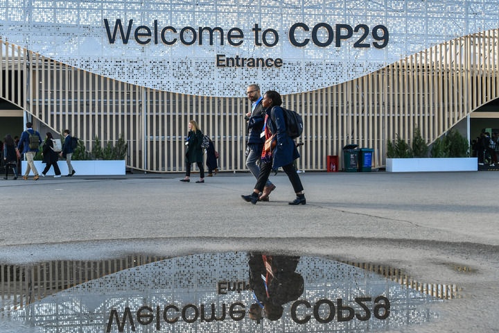 2024年11月15日，在阿塞拜疆首都巴庫，人們經(jīng)過聯(lián)合國氣候變化巴庫大會的會場。新華社記者 曹陽 攝