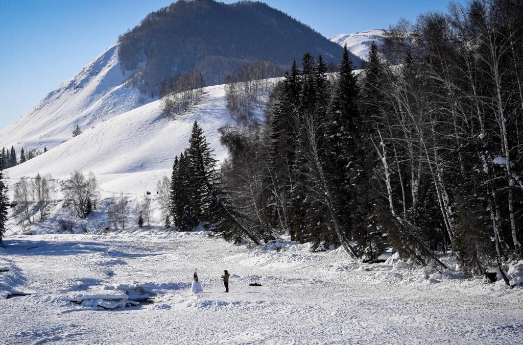 2024年2月5日，兩名游客在新疆阿勒泰地區(qū)布爾津縣禾木村拍照。新華社記者 馬鍇 攝