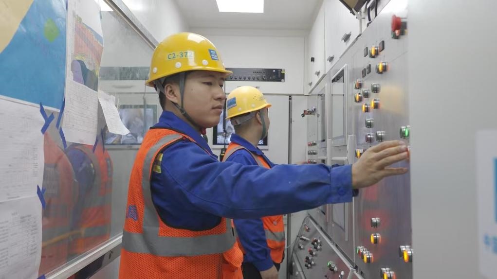 盾構(gòu)司機何曉波在駕駛室內(nèi)調(diào)試盾構(gòu)機參數(shù)。（劉芬攝）