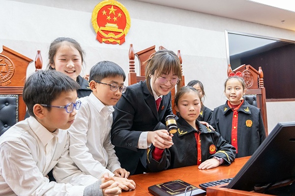 圖①：干警帶同學(xué)們體驗敲法槌。