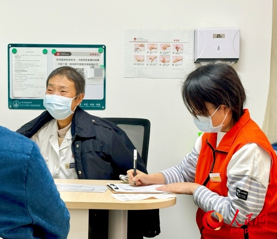 秦苑（中）接診患者。人民網(wǎng)記者 金慧慧攝