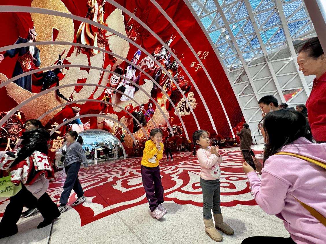 乙巳蛇年春節(jié)期間，影迷在《哪吒之魔童鬧?！肪薹?bào)前拍照打卡。