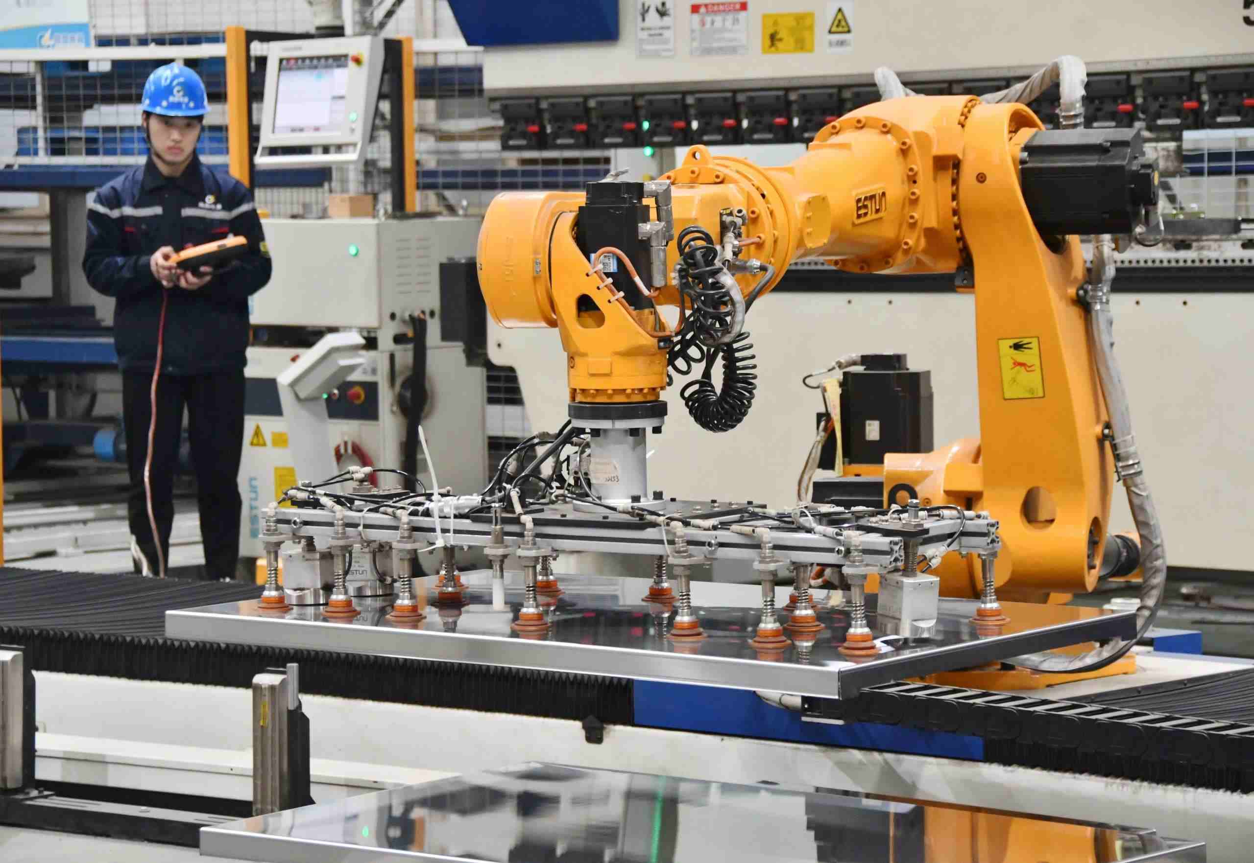 △2025年2月21日，河北邯鄲永年區(qū)工業(yè)園區(qū)的一家企業(yè)，工人正在操控工業(yè)機器人作業(yè)。